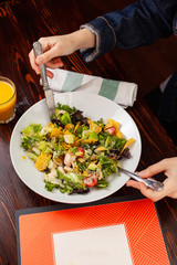 Girl fills salad with hands and cutlery