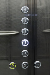 Interior and closeup of metal buttons in elevator