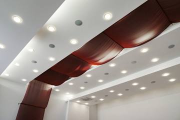 Modern layered ceiling with embedded lights and red cloth