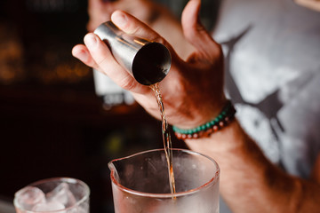 Fototapeta na wymiar Brutal bartender pours Negroni cocktail
