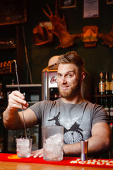 Brutal Barman cools the glass for the preparation of an alcoholic cocktail
