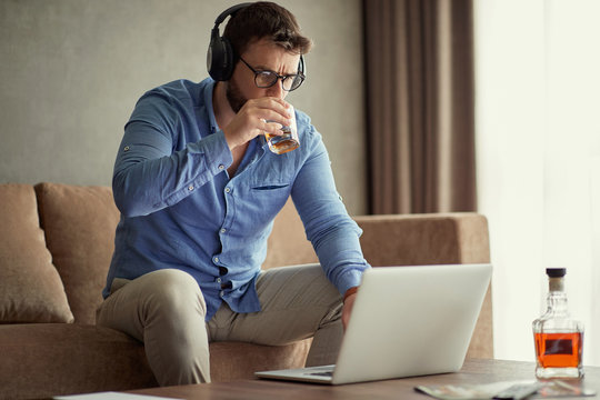 Businessman Is Drinking Whisky While Working At Business Project From A Home .