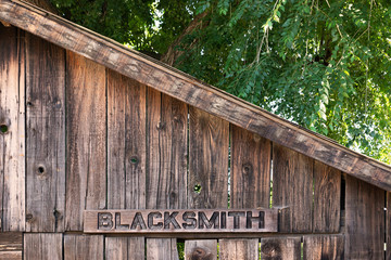 Wooden blacksmith sign on wood storefront