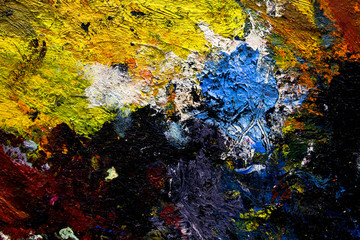 multi-colored strokes of oil paint on the artist's palette. background