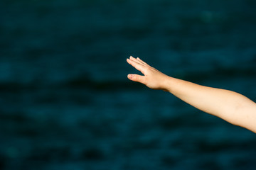 girl stretches her hand away by the sea