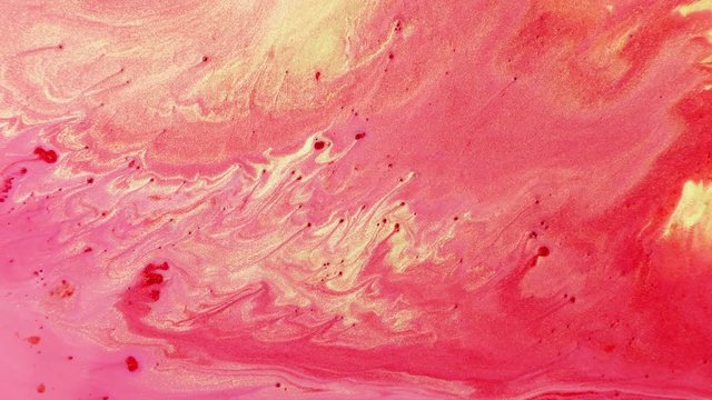 Colorful sparkling paints mix in beautiful patterns. Oil ink of red, yellow, pink and other colors spread on the surface and mix one into another creating amazing textures and design.