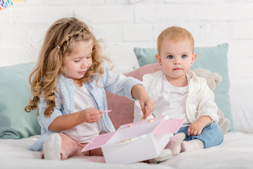 adorable children playing on bed in children room