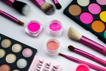 Makeup. Pink make up brushes. Eye shadow. Pink pigments, eyelashes. Beautiful bright background