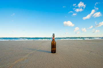 beach of the Baltic Sea with beer bottle and surf