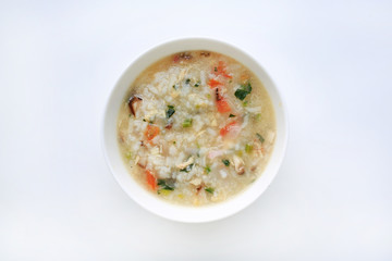 Porridge for baby food in white ceramic bowl on white background.