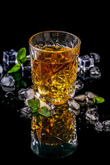 Elite drink for masculine relaxation glasse of whiskey and ice on black background, copy space. concept luxury drink