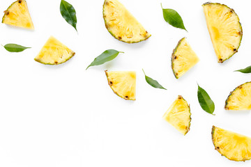 Naklejka premium Slices pineapple with green leaves isolated on white background. Flat lay, top view