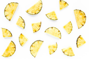 Slices pineapple with green leaves isolated on white background. Flat lay, top view