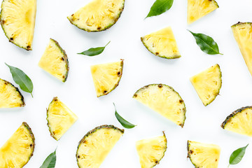 Slices pineapple with green leaves isolated on white background. Flat lay, top view