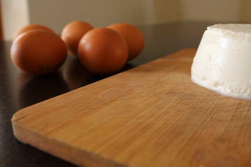 Primo piano composizione tagliere con ricotta e uova, cibo e oggetti da cucina