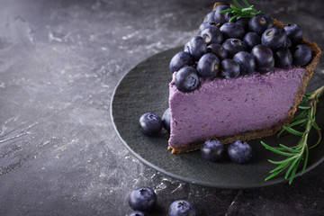 Blueberry vegan cheesecake. Dark photo on black background