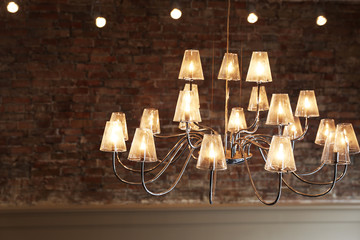 Big vintage electric lamps in the cafe on bricks wall background.