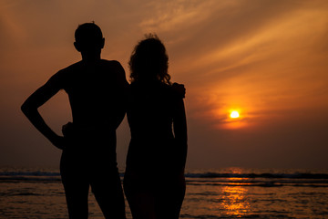 Middle aged woman elderly lover and young man hugging at sunset on the beach by the sea.loving couple by the ocean romantic vacation Valentine's Day February 14