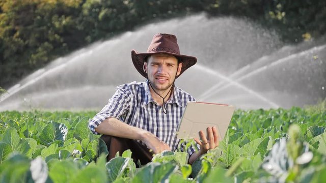 Portrait of happy farmer using digital tablet.