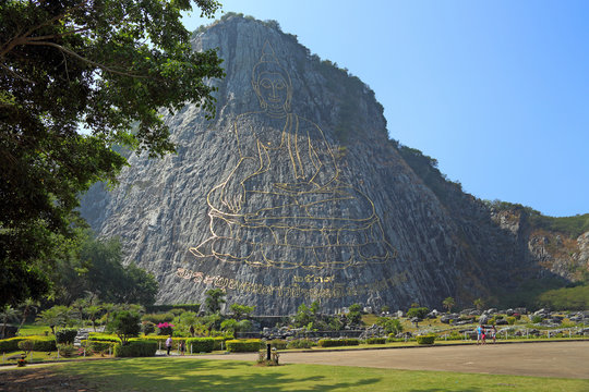 Tourists walk in the Park on the background of the rock of the Golden Buddha in the vicinity of Pattaya