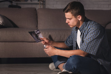 Breakup. Teen setting fire to photo of girlfriend
