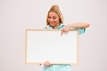 Portrait of young nurse who is holding whiteboard.