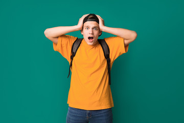 Fototapeta premium Surprised teen guy with hands on head