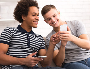 Two friends watching funny videos on smartphone