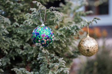 Obraz premium Christmas and New Year decoration on the pine tree branch with lights at the background at night outdoors. Concept of winter holidays.