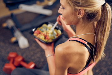 Top view of woman eating healthy food while sitting in a gym. Healthy lifestyle concept. - 239975148