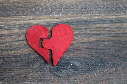 Red puzzle heart on grey wooden background