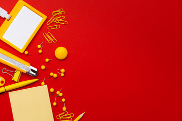 Flat lay, top view office table desk. Workspace with blank adhesive notes,  office supplies on red background.