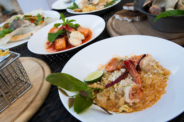 Many Food plate of Baked Scallop Mussel, Spaghetti Crap meat, Seabass fish with potato, Fried Chicken Fish Salad, Shrimp with cut salmon fried, arrange on table top view set up for photo shoot