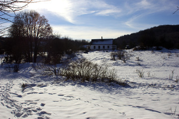 Obraz premium A lone forester house in the winter forest. Snowy winter and white huntsman's house in the forest. Rest in the forest in the forester's house in winter. 