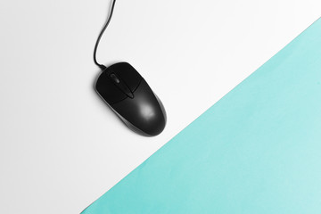Computer mouse on a turquoise paper background