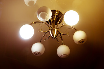 The chandelier is shining. Indoor lamp. Electric lamps