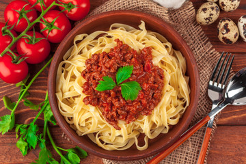 Pasta with meat, tomato sauce and vegetables on the table