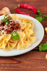 Pasta with meat, tomato sauce and vegetables on the table