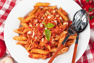 Pasta with meat, tomato sauce and vegetables on the table