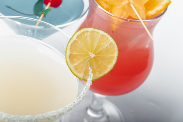 Three different alcoholic cocktails on a white background