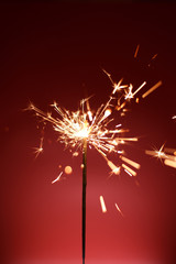 New Year's sparkler on a red background. Celebration