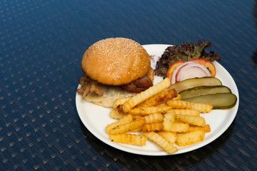 Chicken Beef Beacon Ham Cheese Burger with fried potato chip, Fusion food stylish arrange on glass table along ocean mangrove tree Island, empty copy space for text logo Yummy
