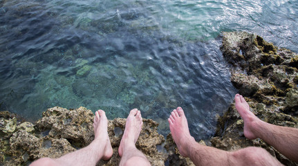 Legs of two men on the beach, relax