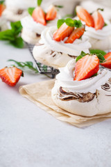 Pavlova cakes with cream and fresh summer berries.