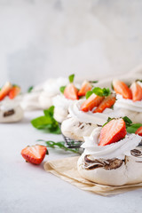 Pavlova cakes with whipped cream and fresh summer berries.