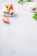 Mini Pavlova cake with cream and fresh summer berries.