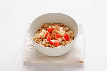 Bowl of oatmeal with apple served on folded towel napkin