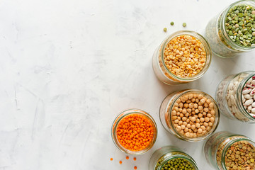 Colorful healthy dried legumes in glass jars