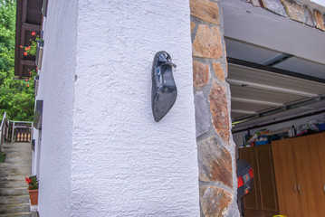 Women high heels shoe hanging at wall beside doors.