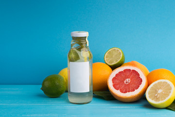 Bottle of detox water with fruits on blue background